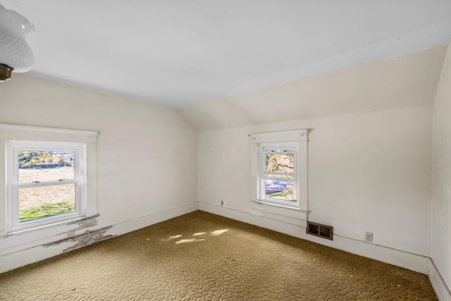 bonus room with carpet flooring and vaulted ceiling