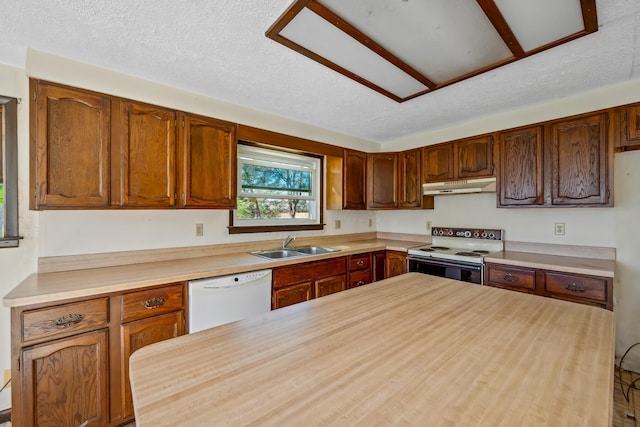 kitchen with a textured ceiling, white appliances, and sink