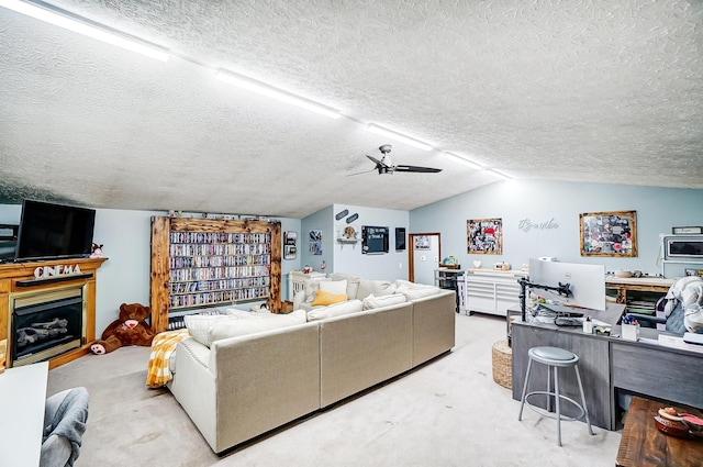 living room with a fireplace, ceiling fan, lofted ceiling, and a textured ceiling