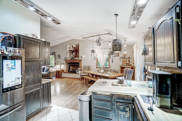 kitchen featuring light tile patterned floors, pendant lighting, and lofted ceiling