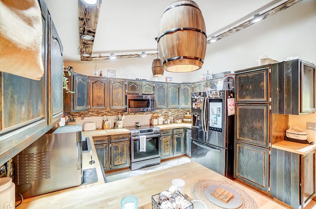 kitchen with sink, backsplash, stainless steel appliances, and light tile patterned flooring