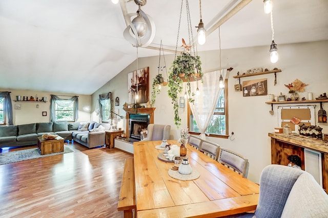 dining area featuring wood-type flooring and vaulted ceiling