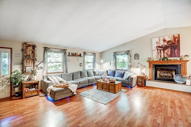 living room with light hardwood / wood-style flooring, plenty of natural light, and lofted ceiling