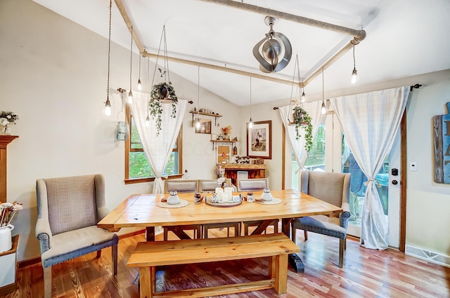 dining area featuring lofted ceiling and hardwood / wood-style flooring