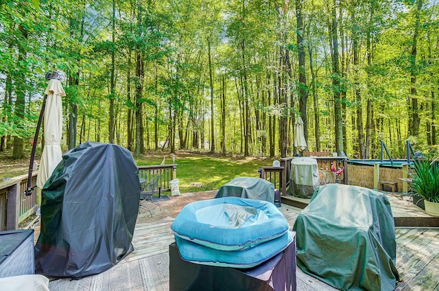 wooden deck featuring a grill and a trampoline