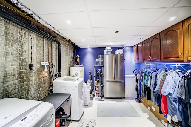 laundry area with cabinets, washing machine and dryer, and water heater