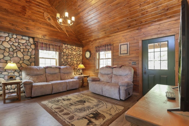 living room with hardwood / wood-style floors, wood walls, wood ceiling, and a chandelier