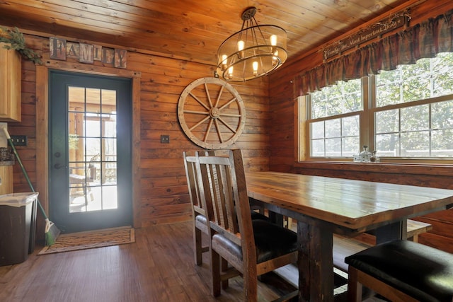 dining area with wood walls, dark hardwood / wood-style flooring, a notable chandelier, and wood ceiling