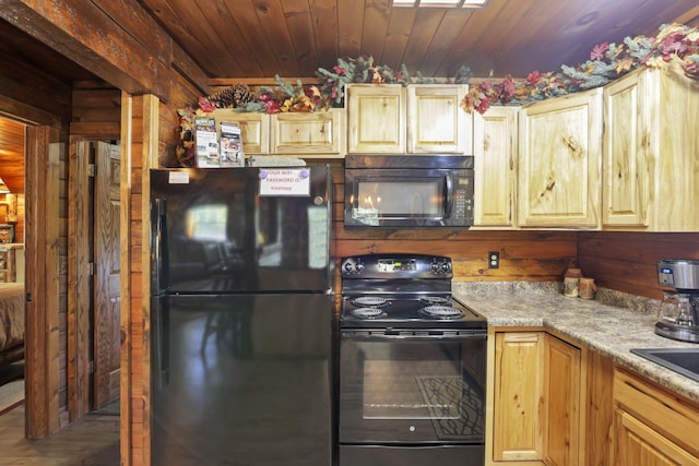 kitchen featuring wooden ceiling, light brown cabinetry, black appliances, and wood walls