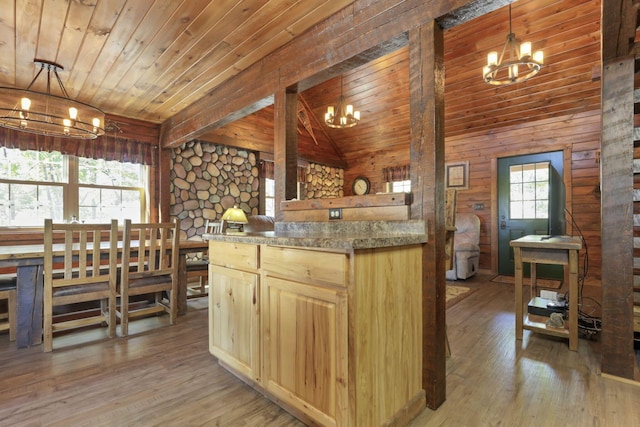 kitchen featuring light brown cabinets, lofted ceiling with beams, decorative light fixtures, and light hardwood / wood-style floors