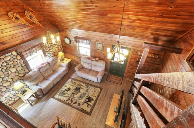 unfurnished living room featuring hardwood / wood-style floors, a notable chandelier, wood walls, and wooden ceiling