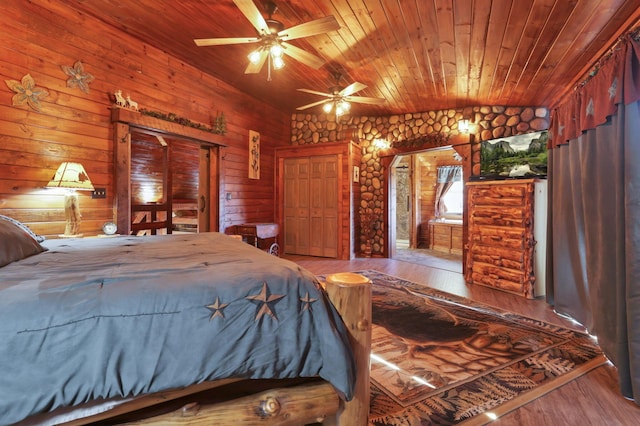 bedroom featuring lofted ceiling, wooden walls, ceiling fan, light wood-type flooring, and wood ceiling