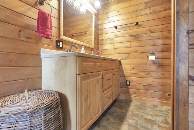 bathroom featuring vanity and wooden walls