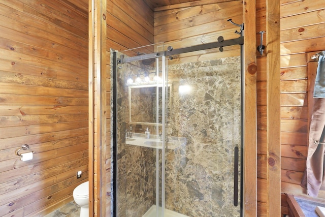 bathroom with wood walls, a shower with shower door, and toilet