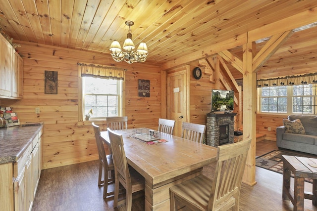 dining room featuring a notable chandelier, wood walls, dark hardwood / wood-style flooring, and wood ceiling