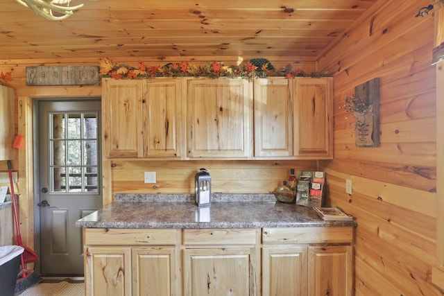 kitchen with wood walls, light brown cabinetry, and wooden ceiling