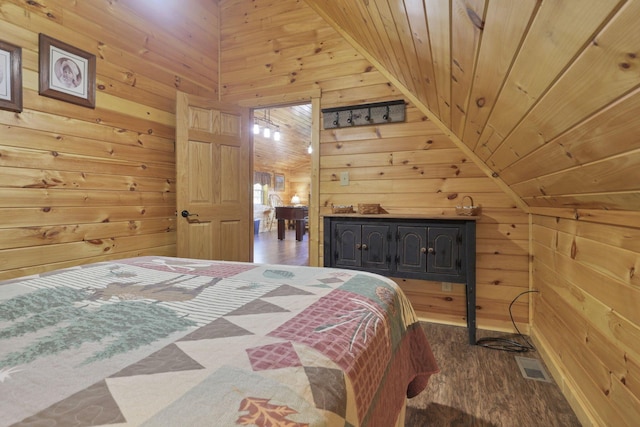 bedroom featuring hardwood / wood-style floors, wood ceiling, wooden walls, and vaulted ceiling