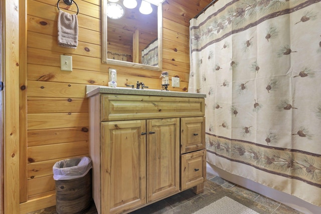 bathroom with a shower with curtain, vanity, and wooden walls