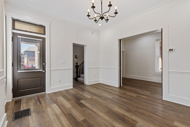 unfurnished dining area featuring a chandelier, crown molding, and dark wood-type flooring