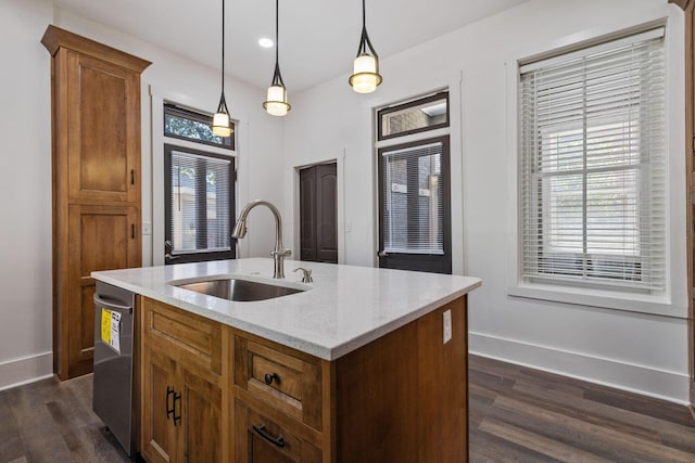 kitchen featuring plenty of natural light, sink, an island with sink, and decorative light fixtures