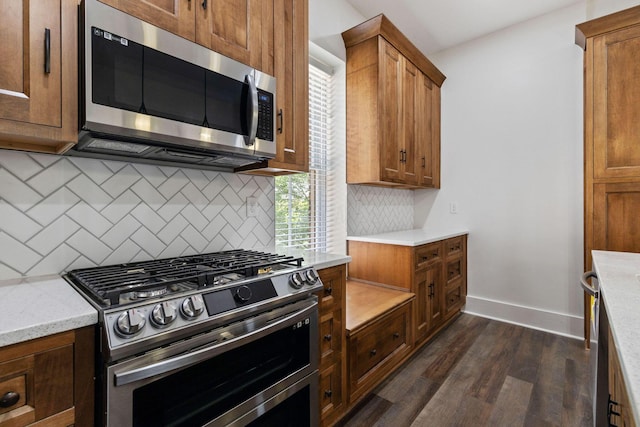 kitchen featuring decorative backsplash, stainless steel appliances, light stone counters, and dark hardwood / wood-style floors