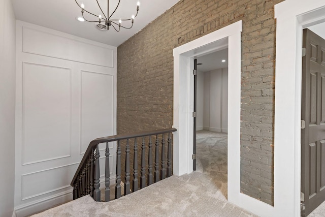 hallway featuring carpet flooring and a chandelier