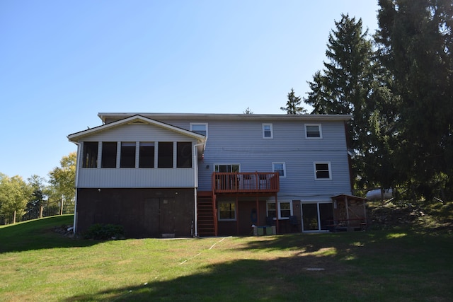 rear view of property featuring a yard, a wooden deck, and a sunroom