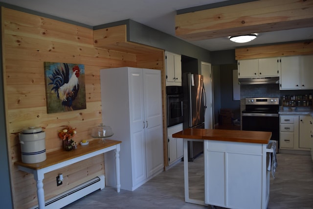 kitchen with wood counters, appliances with stainless steel finishes, tasteful backsplash, white cabinetry, and a baseboard radiator