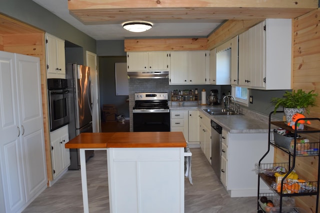 kitchen with white cabinets, sink, tasteful backsplash, a kitchen island, and stainless steel appliances