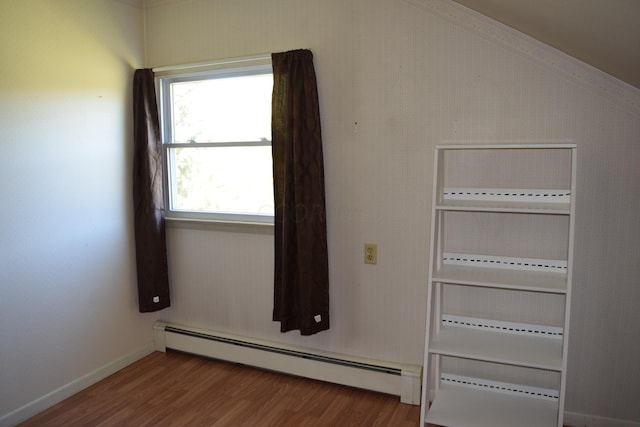 interior space with a baseboard radiator and hardwood / wood-style flooring