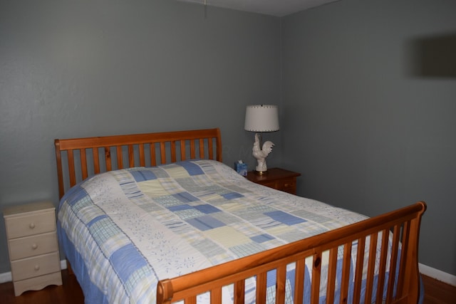 bedroom with dark hardwood / wood-style flooring