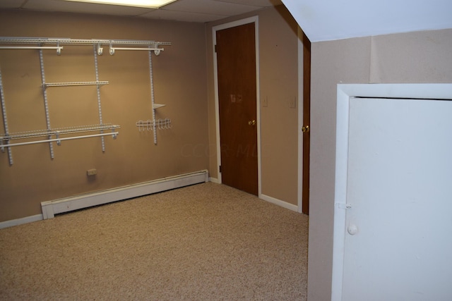 interior space featuring carpet, a baseboard radiator, and a drop ceiling