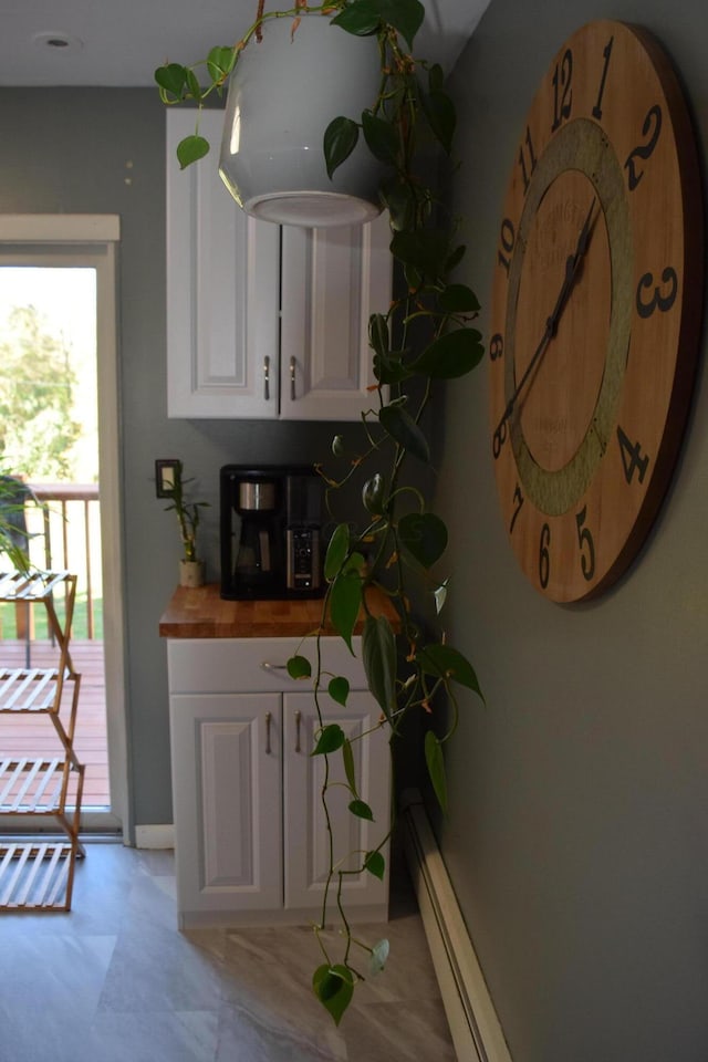 kitchen featuring butcher block countertops, white cabinets, and a baseboard radiator