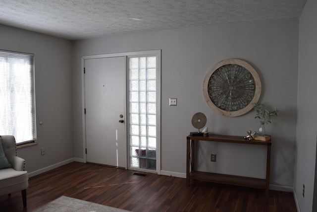 foyer with a textured ceiling and dark wood-type flooring