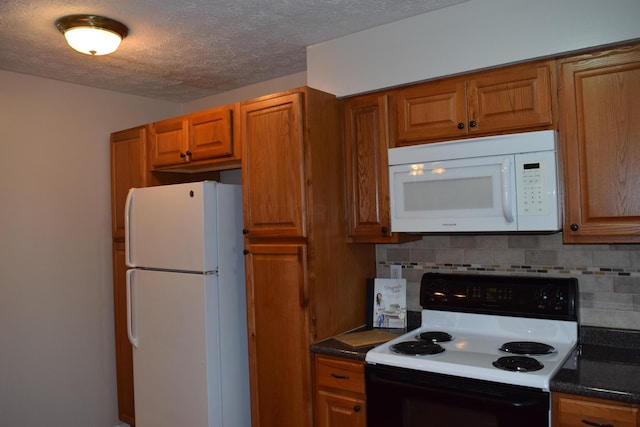 kitchen with a textured ceiling, decorative backsplash, and white appliances