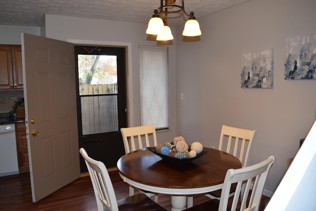 dining area featuring a textured ceiling, an inviting chandelier, and dark hardwood / wood-style flooring