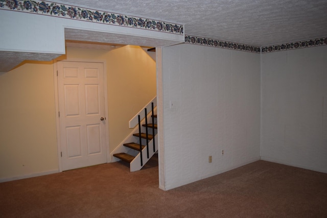 basement featuring a textured ceiling and carpet