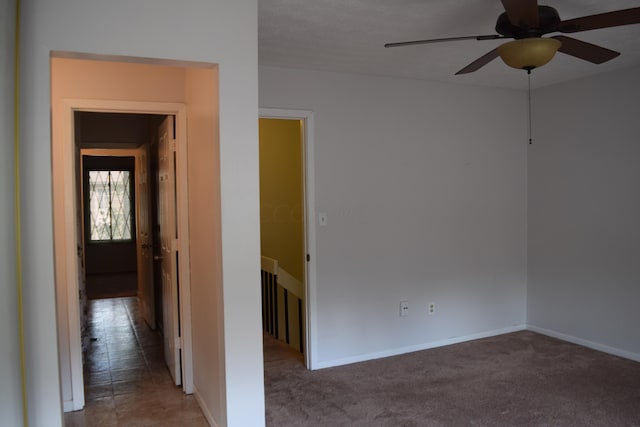 spare room with ceiling fan and carpet