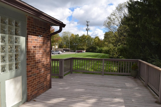 wooden terrace featuring a lawn