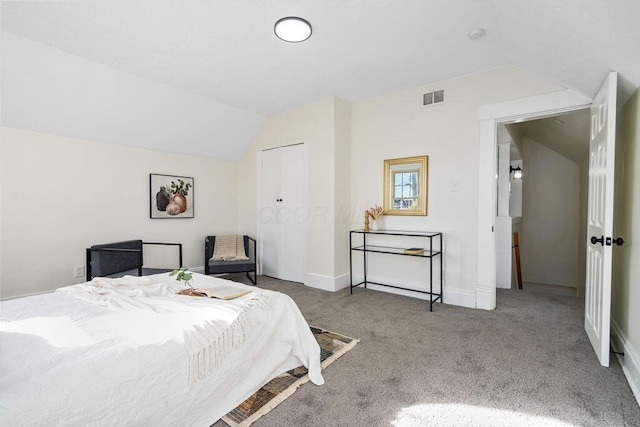 carpeted bedroom with a closet and lofted ceiling