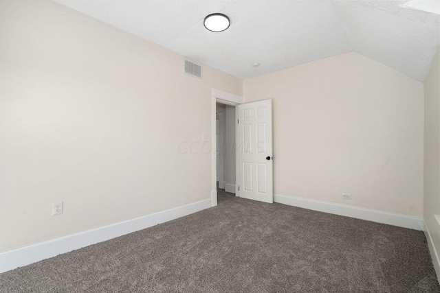 interior space with dark carpet and vaulted ceiling