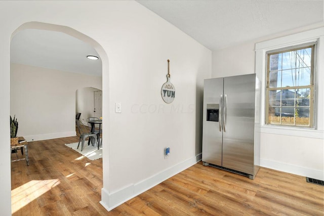 kitchen featuring stainless steel refrigerator with ice dispenser and light hardwood / wood-style floors