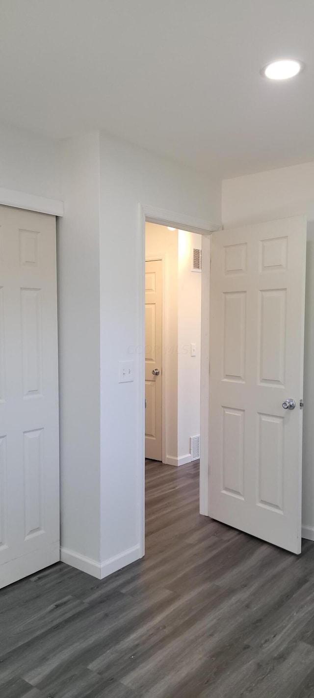 unfurnished bedroom featuring dark hardwood / wood-style flooring and a closet