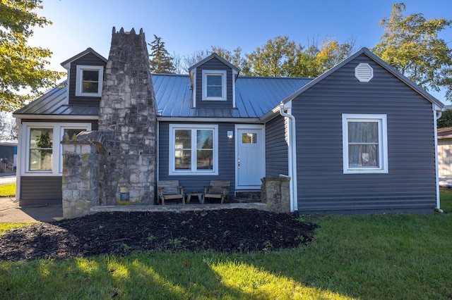 cape cod house featuring a front yard