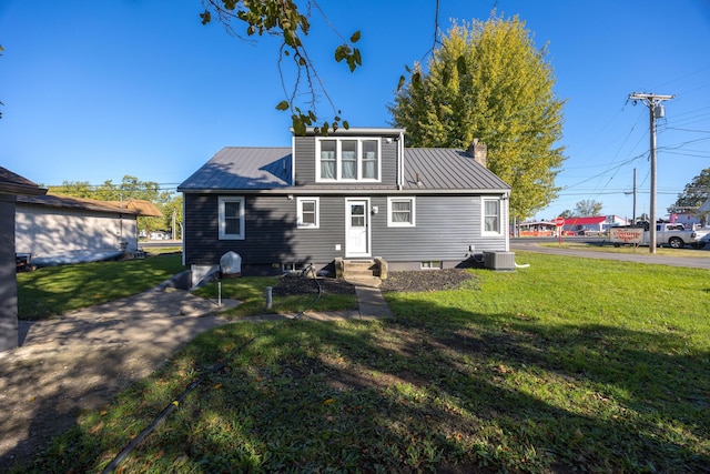 rear view of house with a yard and central air condition unit