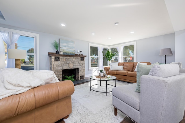 living room with hardwood / wood-style floors and a stone fireplace