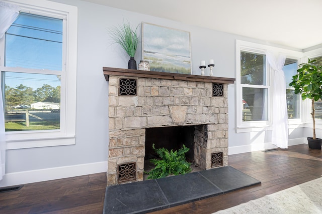 interior details featuring a stone fireplace and hardwood / wood-style flooring