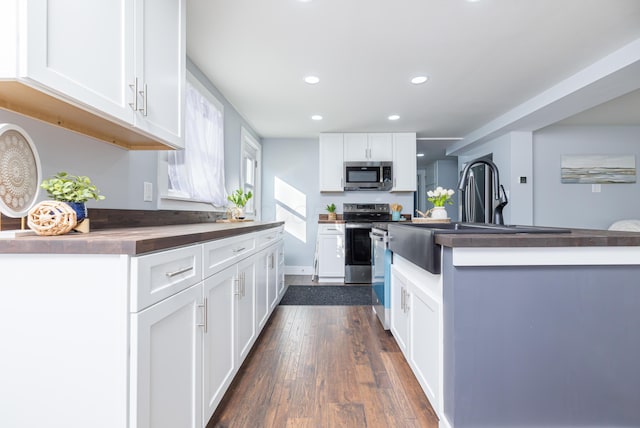 kitchen with white cabinets, sink, dark wood-type flooring, and appliances with stainless steel finishes