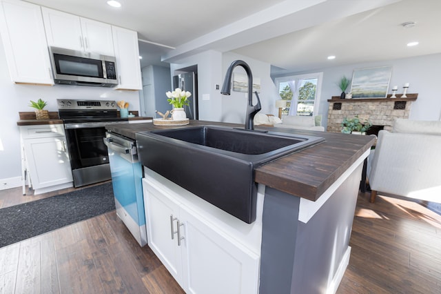 kitchen featuring appliances with stainless steel finishes, dark hardwood / wood-style floors, and white cabinetry