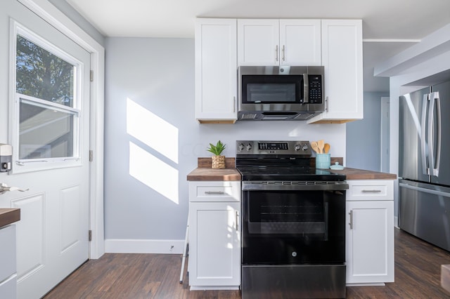 kitchen featuring wood counters, dark hardwood / wood-style flooring, white cabinetry, and appliances with stainless steel finishes